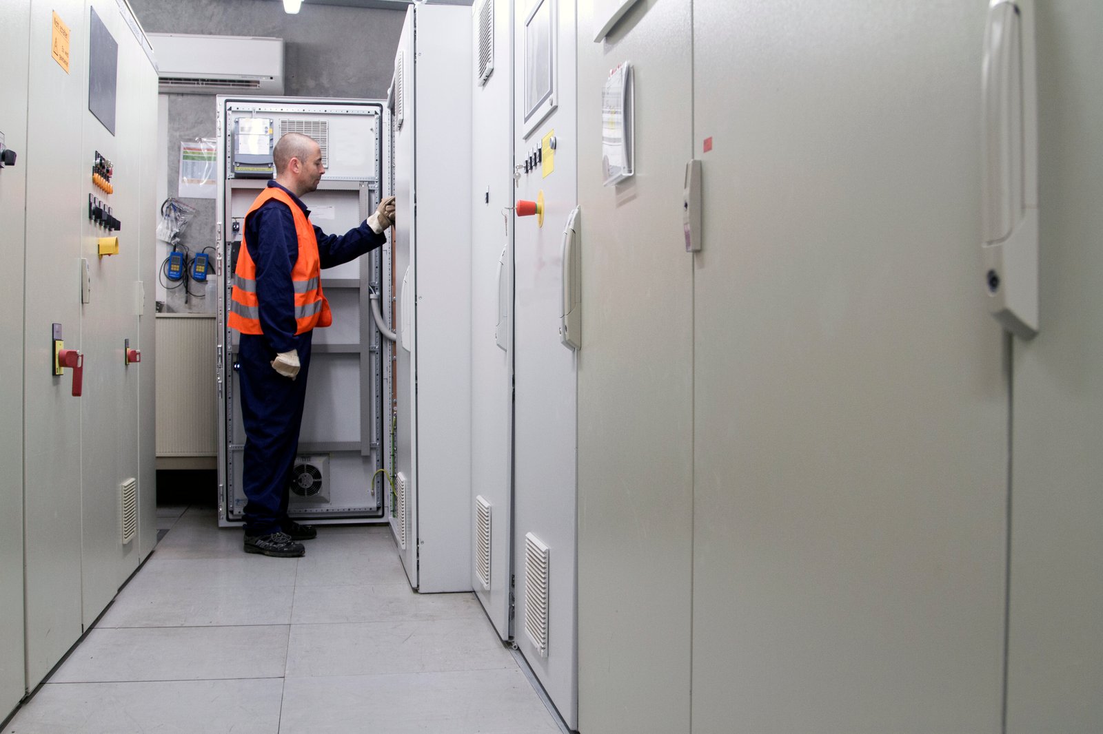 An engineer inspecting electrical equipment in a service corridor