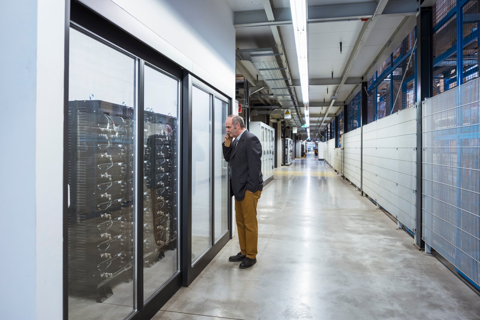 A technician inspecting equipment beside server racks